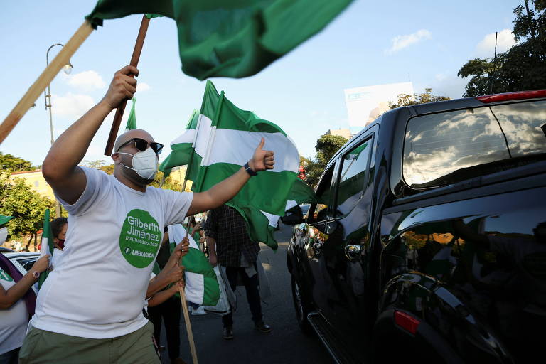 Homem de máscara segura bandeira branca e verde
