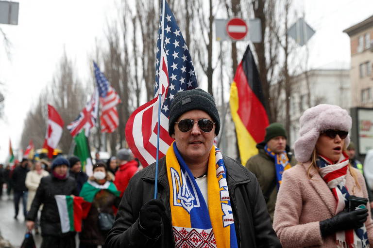 Em Kiev, moradores carregam bandeiras durante manifestação em apoio à Ucrânia. O governo ucraniano tem tentado reduzir as tensões e afirma que a possibilidade de resolver a crise com a Rússia por meio da diplomacia é maior do que a chance de um ataque militar