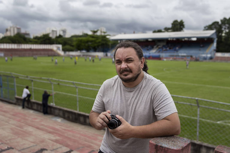 Fernando Martinez, com máquina fotográfica na mão, durante partida entre Nacional e Comercial, pela Série A3 do Paulista
