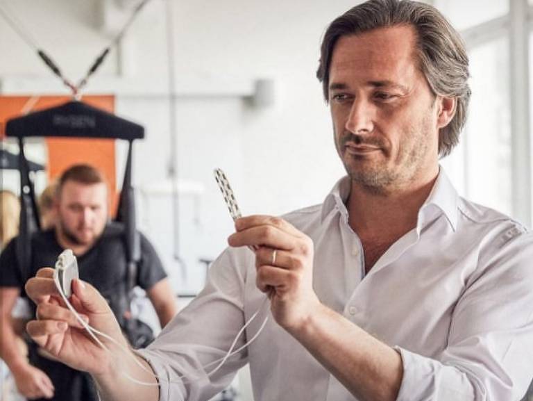 O neurocientista francês Grégoire Courtine mostra o eletrodo que leva o estímulo elétrico à medula espinhal dos pacientes