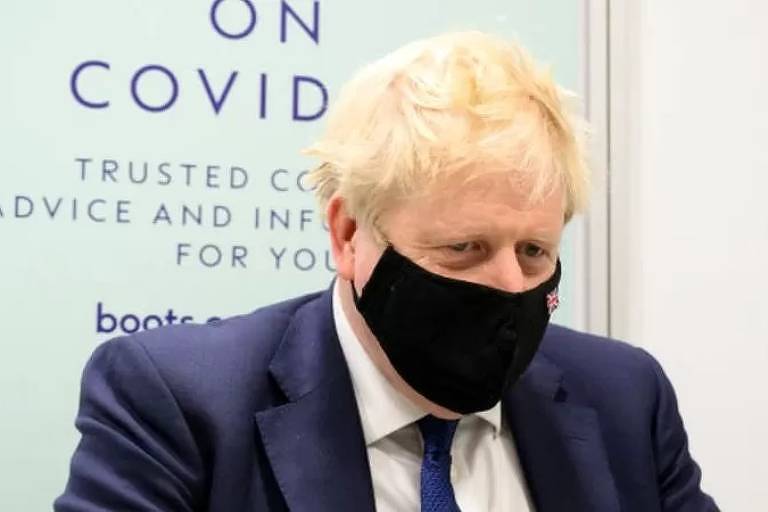 Imagem em primeiro plano mostra Boris Johnson de máscara