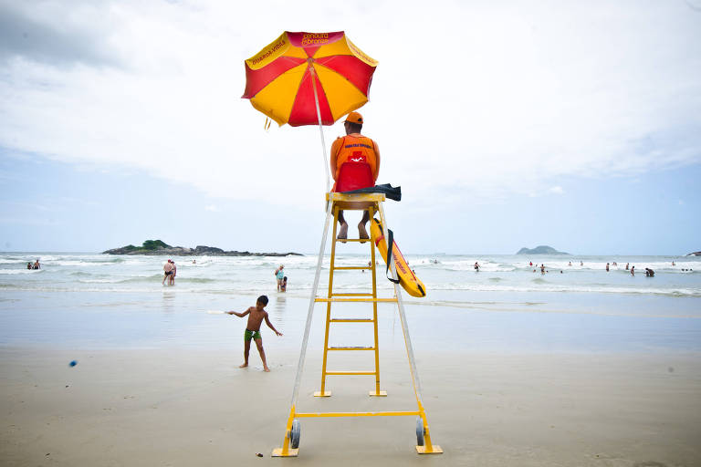 Salva-vidas observa movimento dos banhistas na praia de Pitangueiras, no Guarujá (SP)