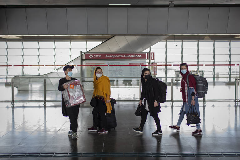 Carregando seus pertences, Abdullah, Najiba, Azadeh e Setara caminham em direção à plataforma do trem do Aeroporto de Guarulhos