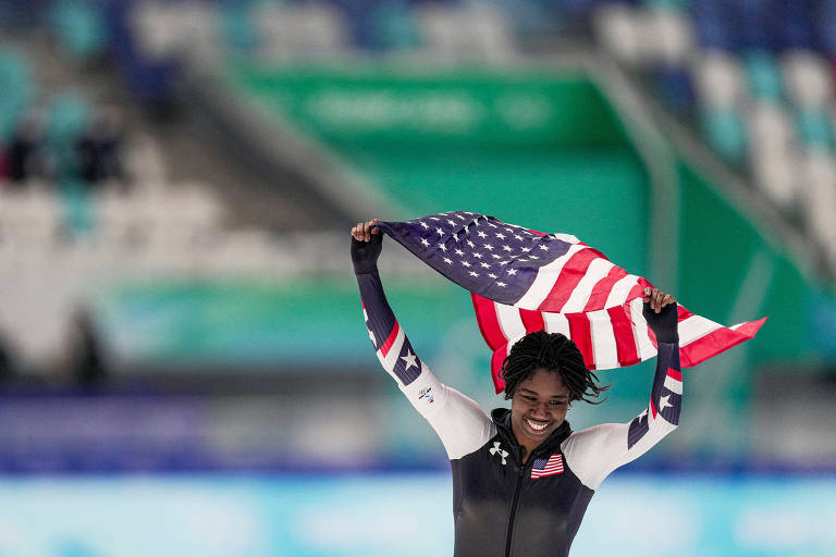Erin Jackson comemora após ganhar o ouro na prova de 500 metros da patinação de velocidade 