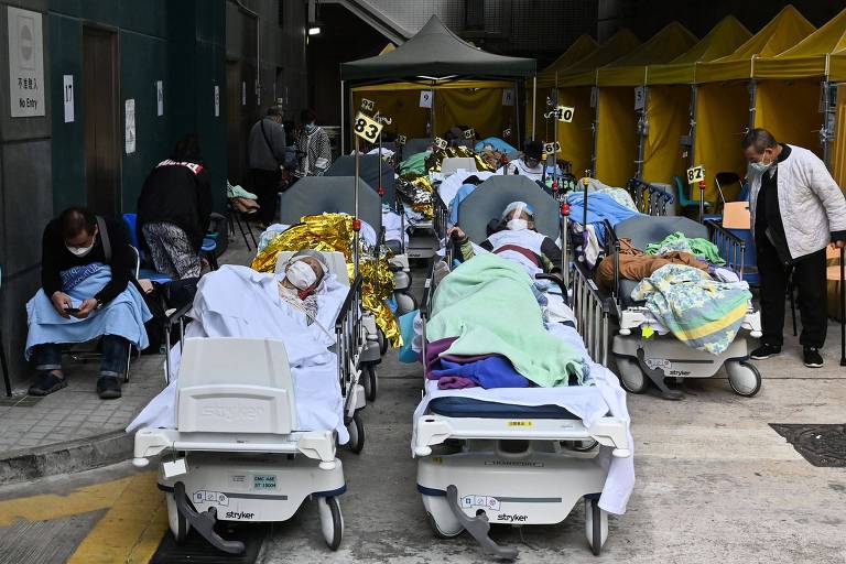 Pacientes ocupam leitos do lado de fora do centro médico Caritas, em Hong Kong, em meio a surto da Covid