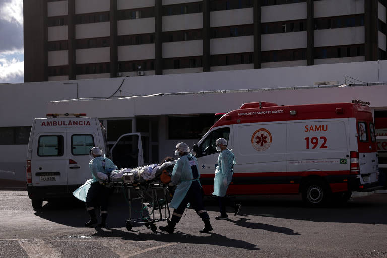 ambulâncias com macas e pacientes em frente a hospital