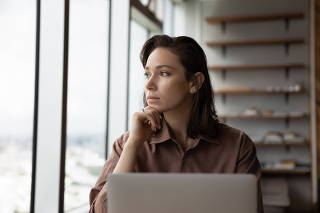 Pensive woman work on laptop look in distance thinking