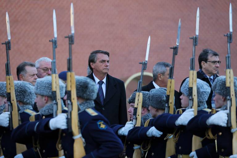 De pé, o presidente Jair Bolsonaro participa de cerimônia em viagem à Rússia