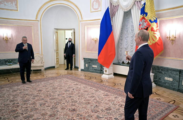 Putin (de costas) e Orbán brindam à distância, devido ao temor do russo da Covid-19, no Kremlin