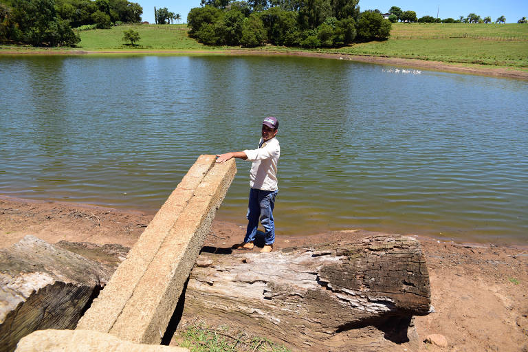 O produtor Amilton Rosa, que tem cerca de 1,80 metro de altura, mostra onde a água do açude familiar costumava chegar, em Espumoso (RS)