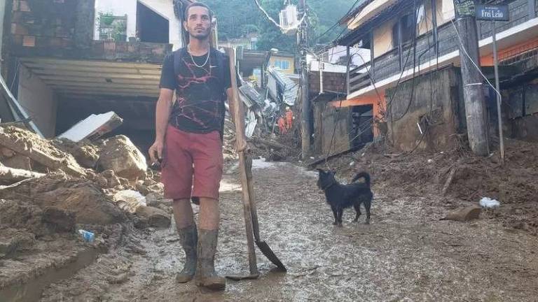 Com uma enxada nas mãos, o feirante Luciano Gonçalves, de 26 anos, tenta ajudar no resgate de corpos