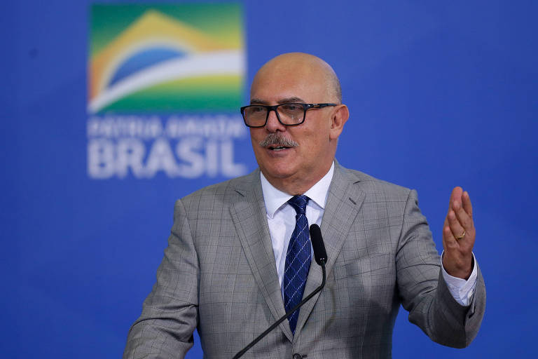 O ministro da Educação, Milton Ribeiro, gesticula com o braço esquerdo durante entrevista em Brasília; ele é careca, usa óculos, um terno cinza, e sua gravata é azul