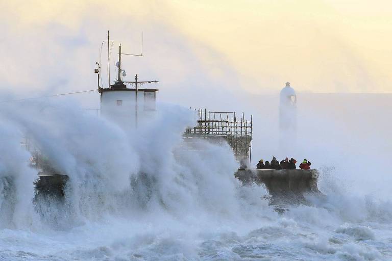 Ondas se chocam contra uma barreira em Porthcawl, no País de Gales, provocadas por fortes rajadas de vento 

