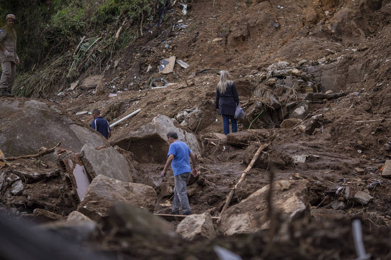 Moradores retiram seus pertences pessoais no meio da destruição provocada pela chuva no bairro Caxambu, em Petrópolis