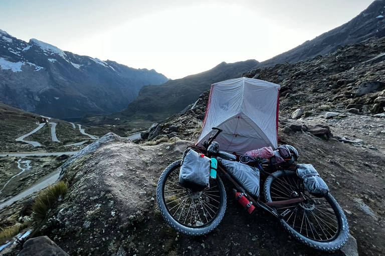 Bicicleta e barraca em ambiente de montanha