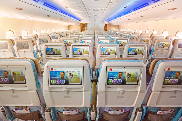 Interior de avião da Emirates com destaque para o sistema de entretetenimento a bordo
