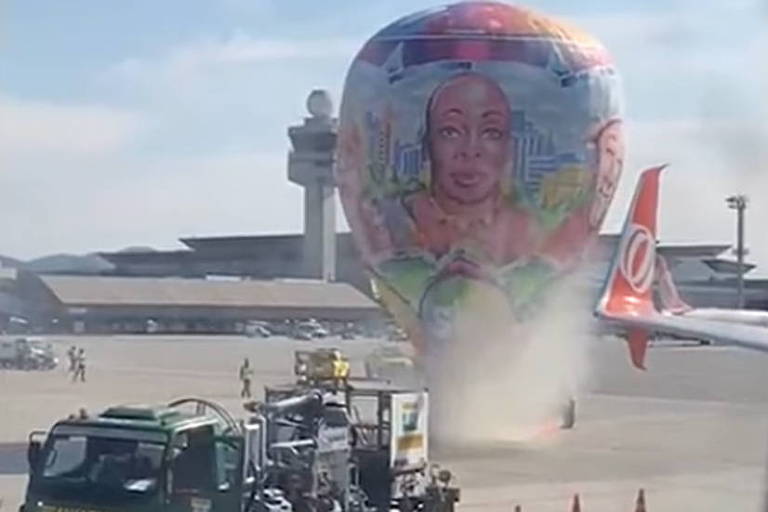 Imagem mostra um um balão próximo a asa de um avião; ao lado, está um caminhão, e sai um pouco de fumaça na região
