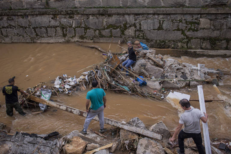 Voluntários dentro de rio durante busca de Gabriel Villa Real