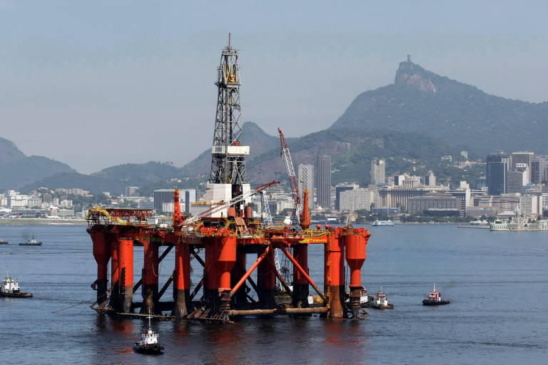 Plataforma de petróleo da Petrobras, com colunas laranjadas, é vista na baía de Guanabara, no Rio de Janeiro. ao fundo, montanhas e prédios