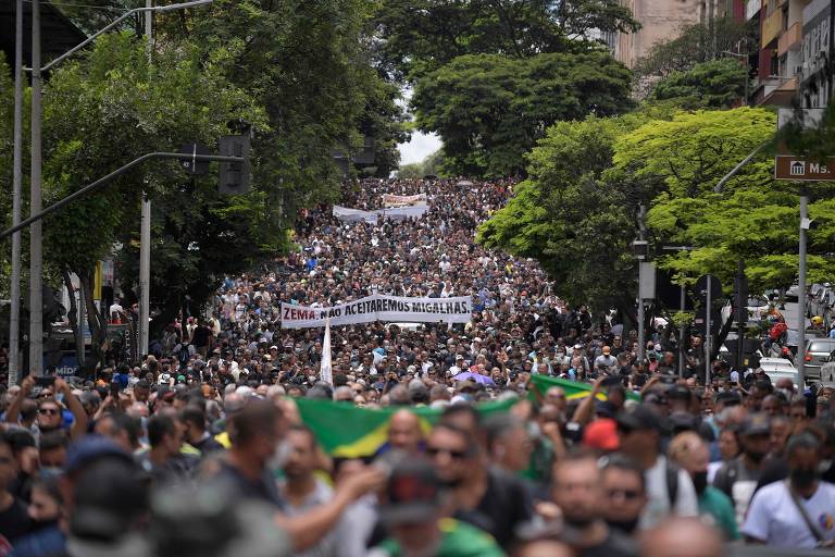 imagem do alto de multidão de pessoas na rua, com algumas bandeiras verde e amarelo
