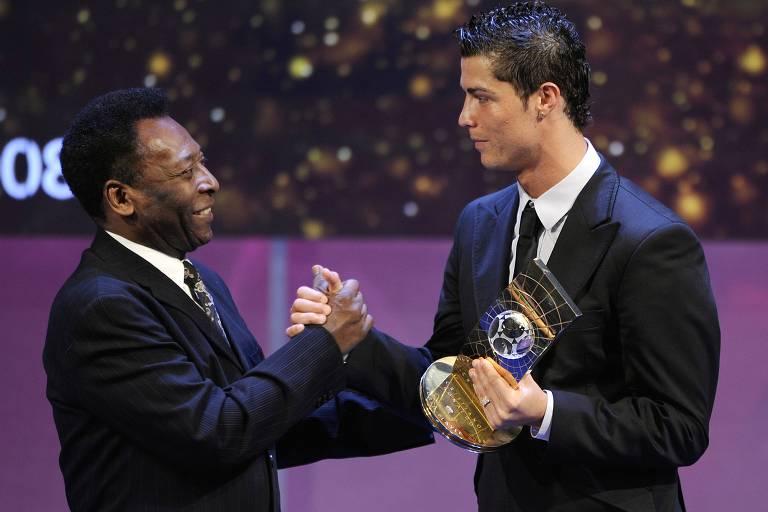 Pelé cumprimenta em Zurique (Suíça) Cristiano Ronaldo, eleito o melhor jogador do mundo em 2008 pela Fifa; o português segura o troféu com a mão esquerda