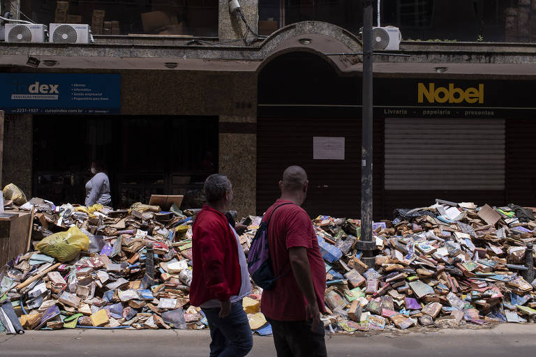 Livros estragados estão acumulados em rua do centro de Petrópolis, região Serrana do Rio de Janeiro
