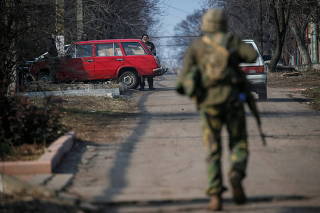 Ukrainian serviceman walks along a street near the front line near the city of Novoluhanske