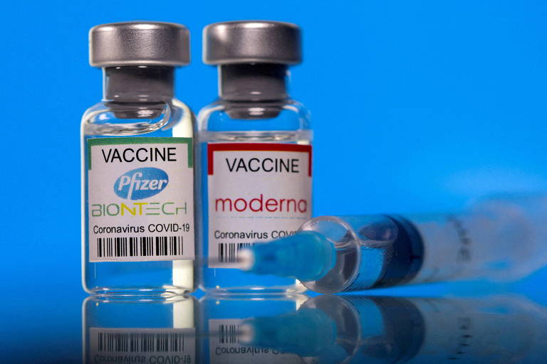 frascos de vacinas e uma seringa com agulha ao lado