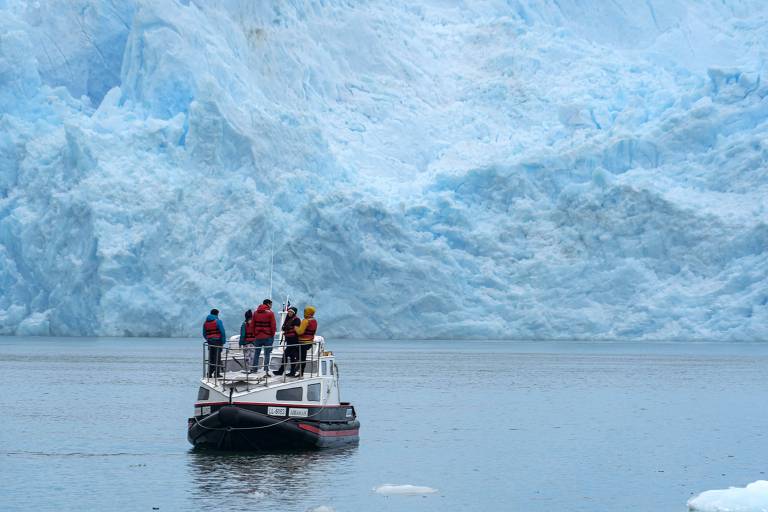 Pessoas observam a geleira San Rafael, no sul do Chile, onde as mudanças climáticas estão derretendo o gelo cada vez mais rapidamente
