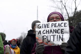 People hold a demonstration against Russia's invasion of Ukraine in front of the Russian embassy in Helsinki