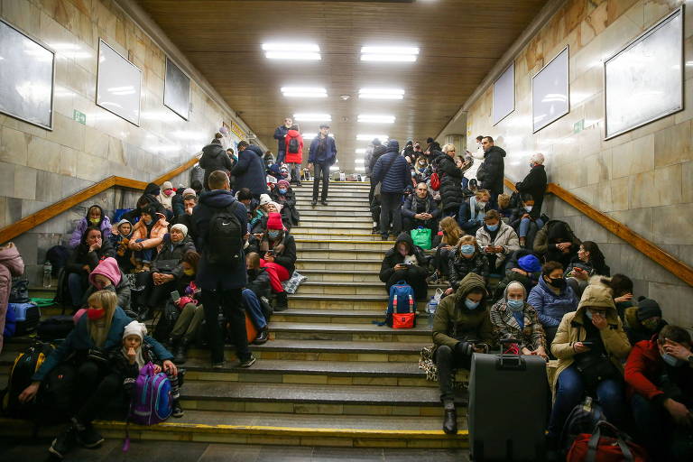 Pessoas sentadas nas escadas de uma estação de metrô em Kiev, na Ucrânia