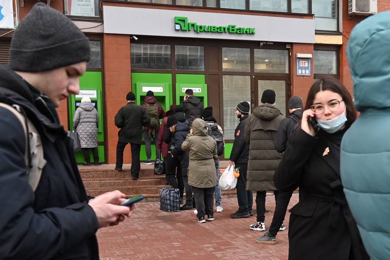 Em desespero, ucranianos também correram para os bancos e caixas eletrônicos para sacar seu dinheiro. Na imagem, uma fila em Kiev, capital ucraniana. O banco central do país suspendeu saques em moeda estrangeira e limitou a quantidade de moeda local que as pessoas podem retirar
