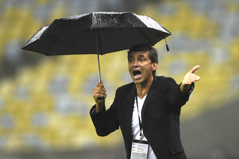 Fabián Bustos, de guarda-chuva, durante confronto com o Fluminense, pela Libertadores de 2021