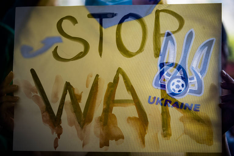 cartaz amarelo em que se lê: stop war