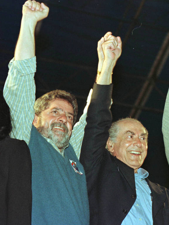 Lula (PT), com sua tradicional barba, e o careca Leonel Brizola (PDT) erguem os braços, lado a lado, em comício no Rio de Janeiro antes da eleição presidencial de 1998