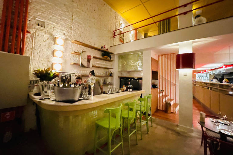 A foto mostra o interior de um restaurante com um balcão de bar em primeiro plano