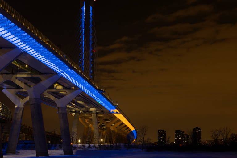 A ponte Samuel de Champlain, em Montreal (Canadá), está iluminada em amarelo e azul, cores da bandeira ucraniana, para mostrar o apoio ao povo do país atacado pela Rússia
