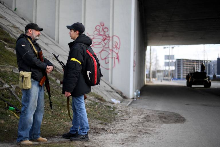 Civis protegem uma estrada principal que leva a Kiev; forças ucranianas lutam contra invasores russos nas ruas da capital