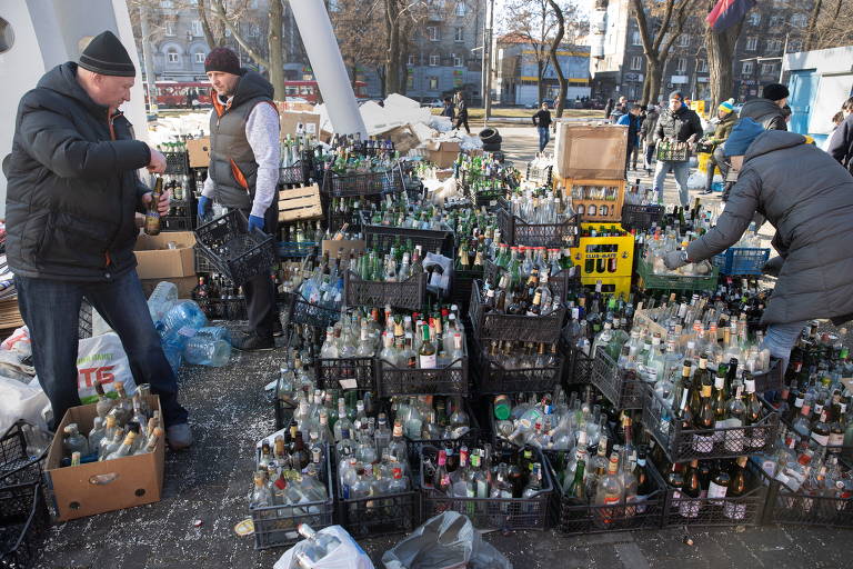 Civis ucranianos pegam garrafas para prepararem coquetel molotov; veja fotos da guerra na Ucrânia