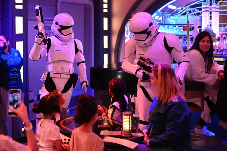 Stormtroopers interagem com hóspedes em um dos espaços do hotel Star Wars: Galactic Starcruiser