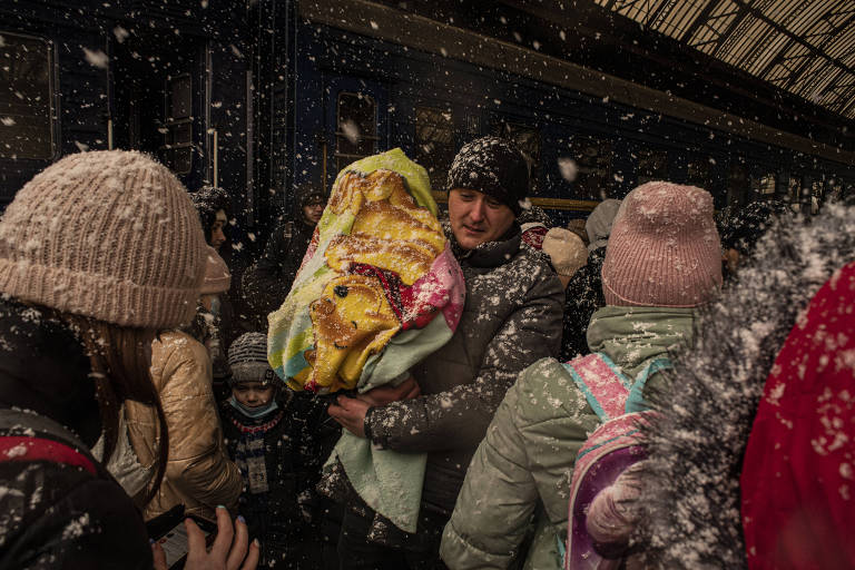 Civis na estação de trem de Lviv tentam escapar da guerra na Ucrânia