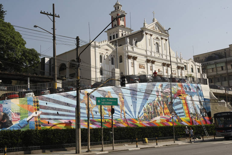 Fachada da Igreja do Calvário, em Pinheiro, zona oeste de São Paulo. Igreja aparece ao fundo com um muro grafitado à frente