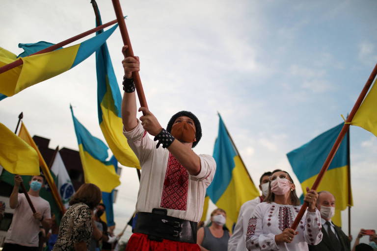 Homem agita bandeira da Ucrânia durante manifestação