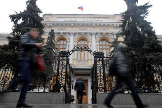 FILE PHOTO: People walk past the headquarters of Russia's Central Bank in Moscow