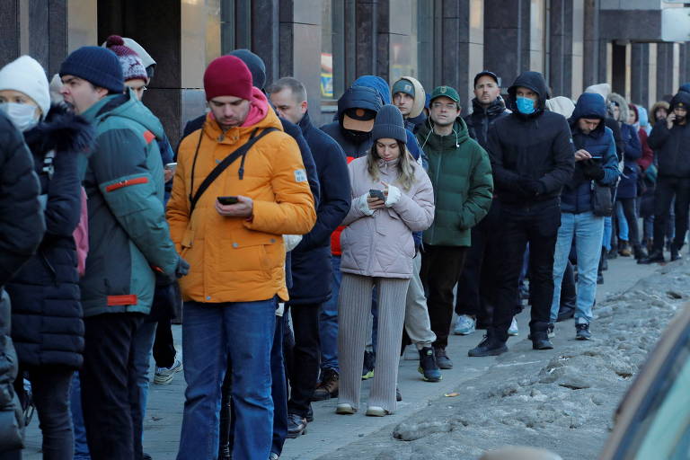 Pessoas fazem fila para usar um caixa eletrônico em São Petersburgo no domingo (27/02)