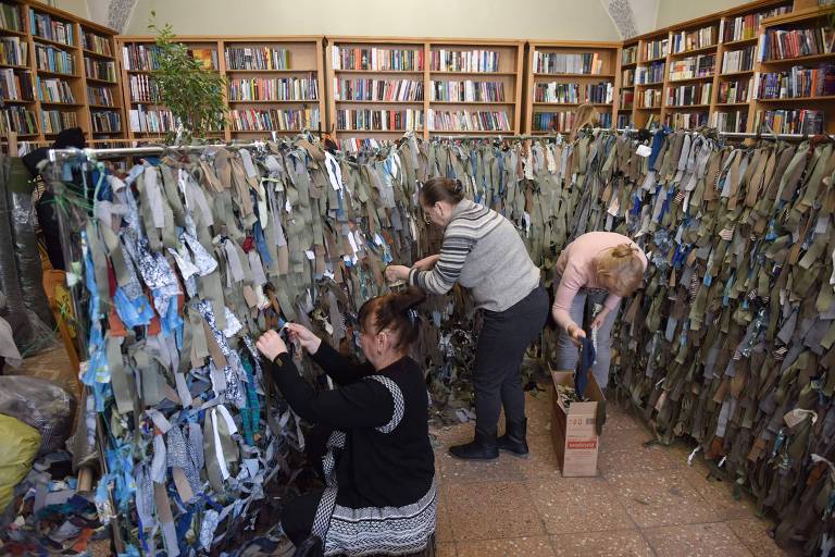 Voluntários fazem redes de camuflagem para os militares ucranianos em uma biblioteca na cidade ucraniana ocidental de Lviv