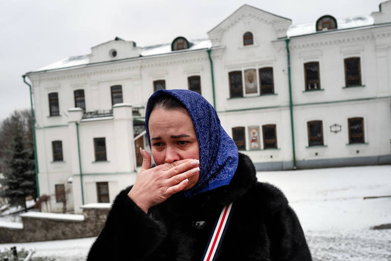 Na frente do Mosteiro das Cavernas em Kiev, Marina Shuyeva, 37, chora depois de orar por sua família que vive em Kharkiv