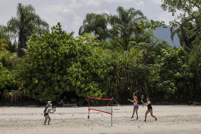 Turistas aproveitam o dia de sol e baixo movimento para praticar esportes nas areias da praia de Juquehy, litoral norte de São Paulo