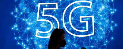 A woman walks past a 5G logo during GSMA's 2022 Mobile World Congress (MWC), in Barcelona, Spain, March 1, 2022. REUTERS/Albert Gea ORG XMIT: GDN