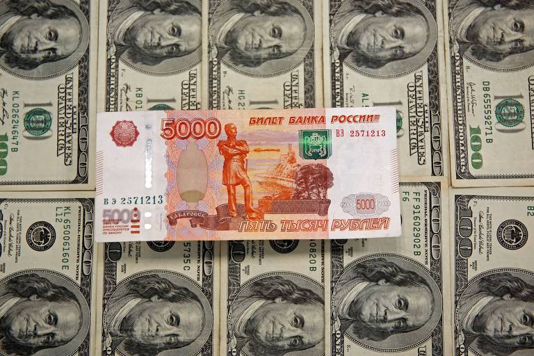 Cédula de 5000 rublos em cima de cédulas de dólares